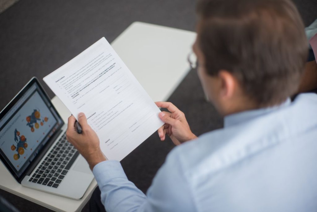 Localization professional reviewing a remediated multilingual PDF alongside compliance data